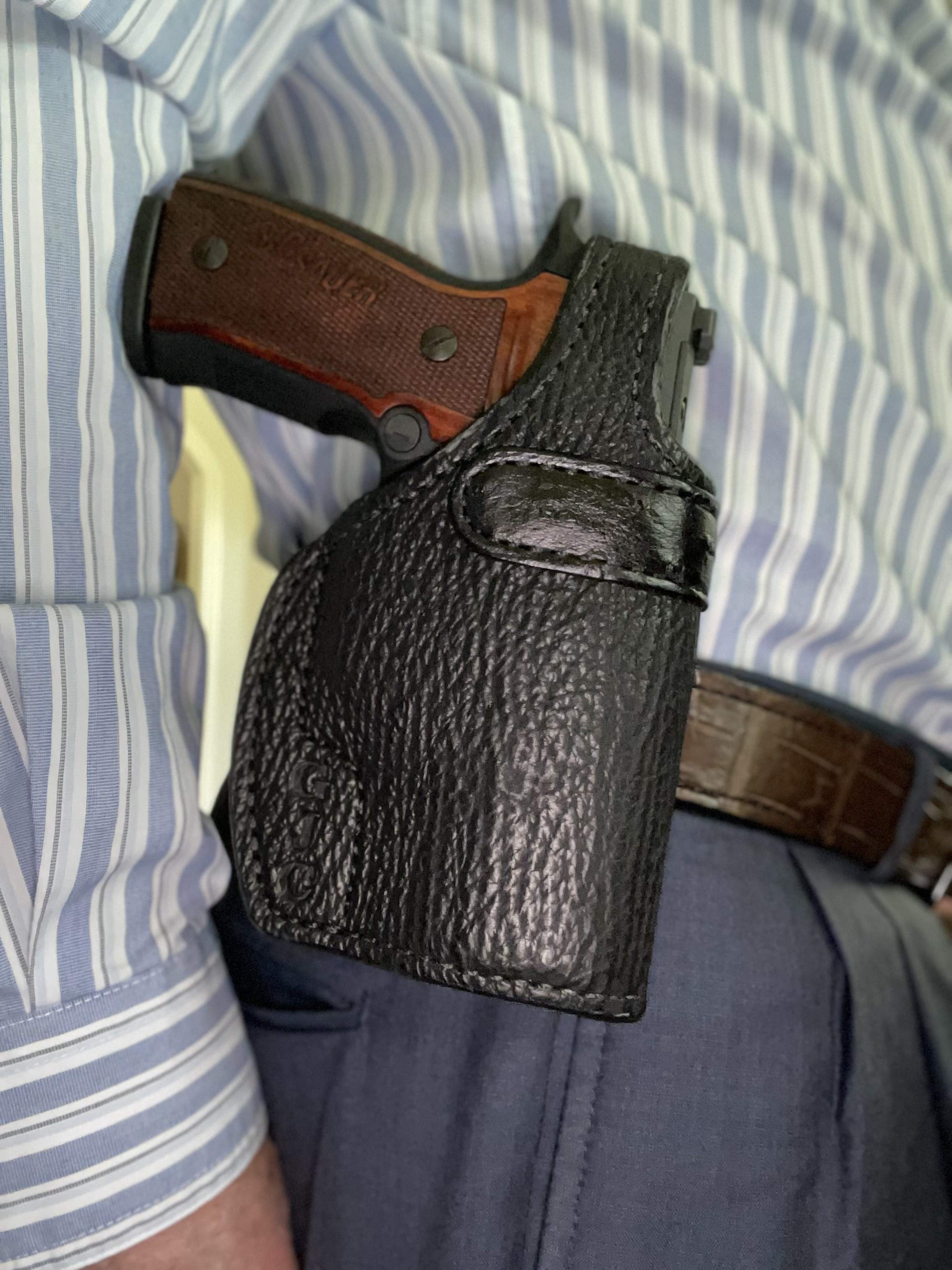 Sig pistol in a custom paddle holster showing fit and leather contact points