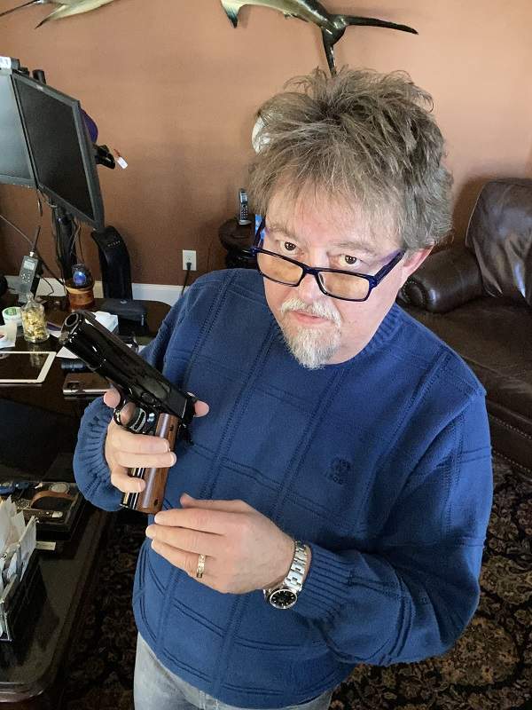 Greg retrieving the Colt Gold Cup National Match pistol from the display case