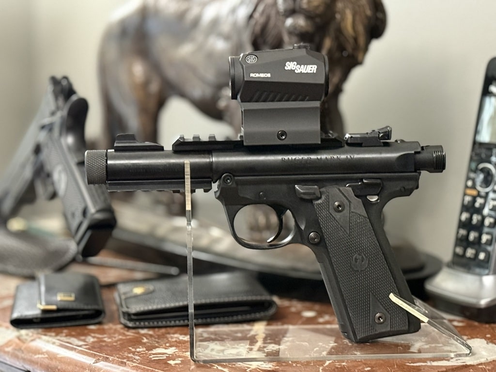 Close view of a Ruger 22 pistol muzzle and receiver with a red dot optic